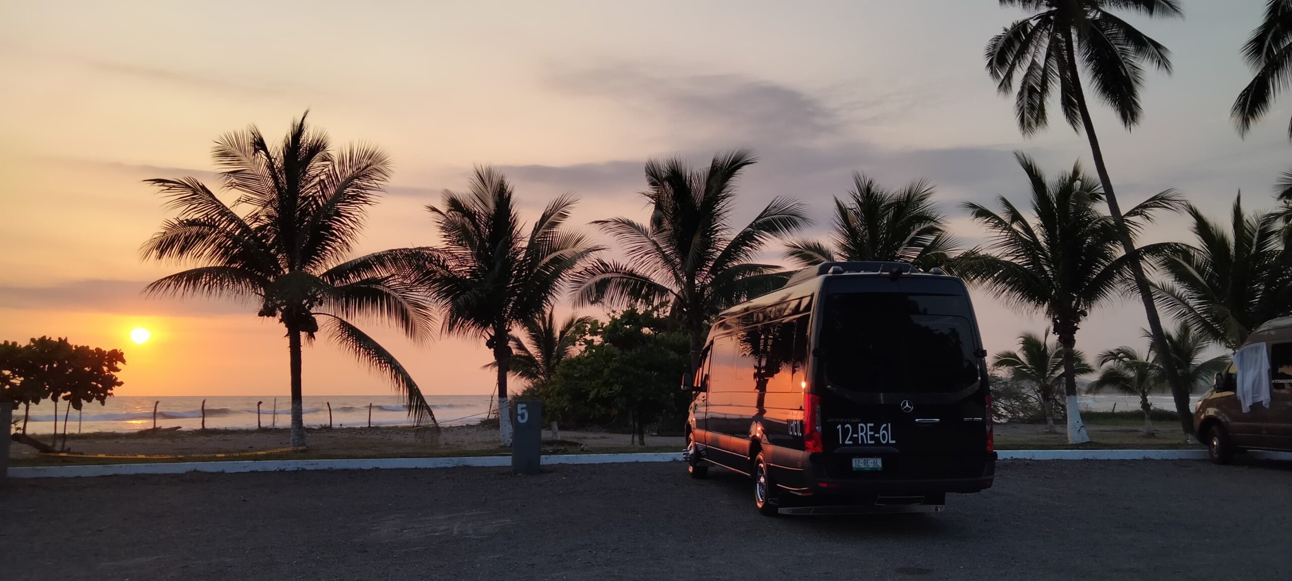 0fd31e30-daef-4e42-9b11-ffc1596ec814 camioneta sprinter negra con el atardecer en una de las playas del pacifico mexicano